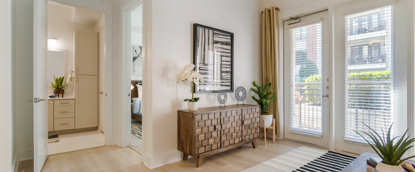 a living room with a large window and a door at The Allure