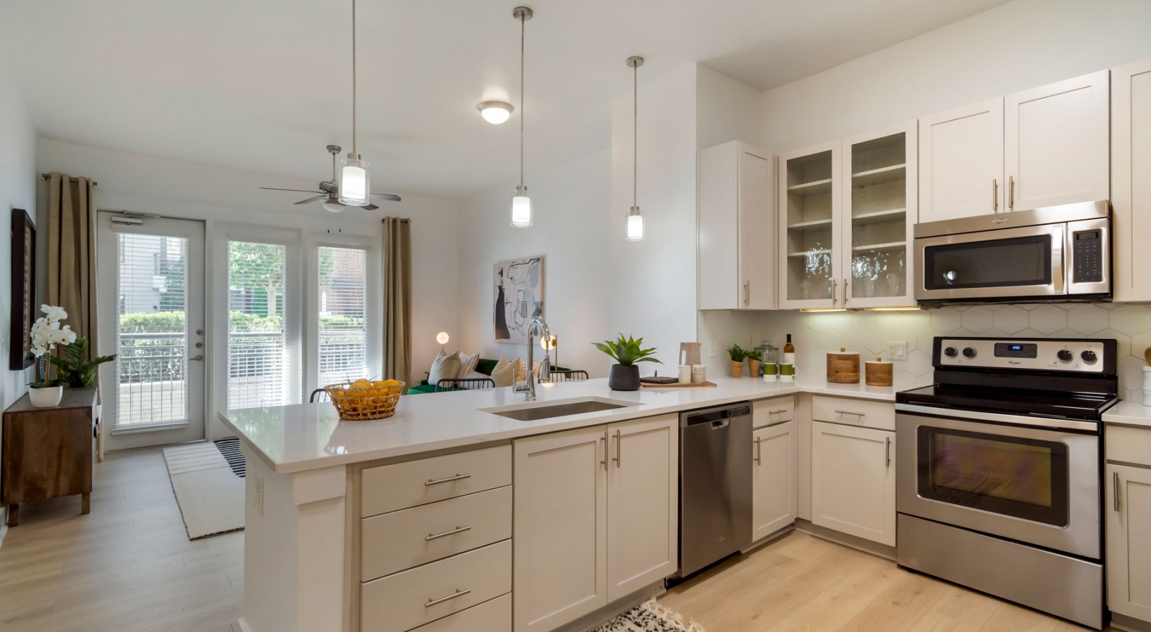 a kitchen with stainless steel appliances and white cabinets at The Allure