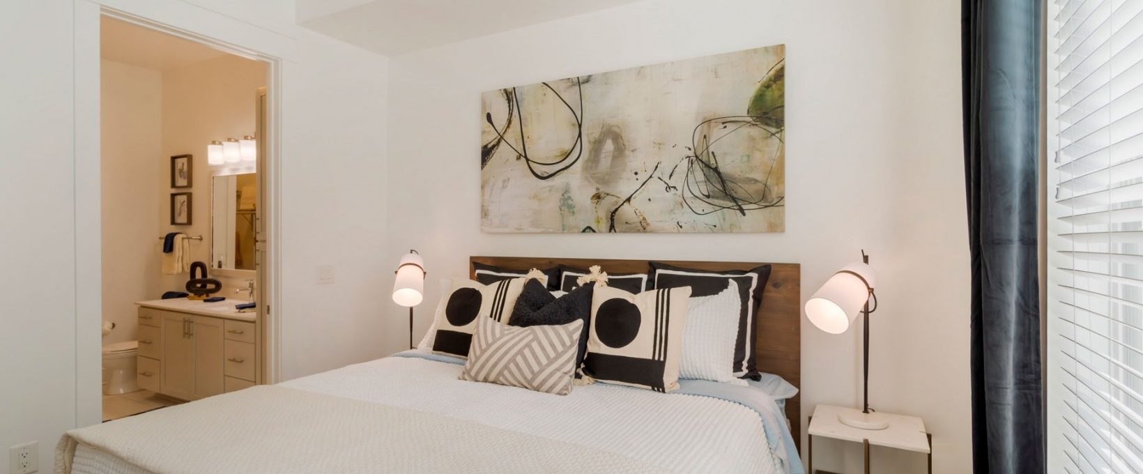 a bedroom with a white bed and a ceiling fan at The Allure