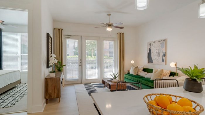 a living room with a table and chairs and a fan at The Allure