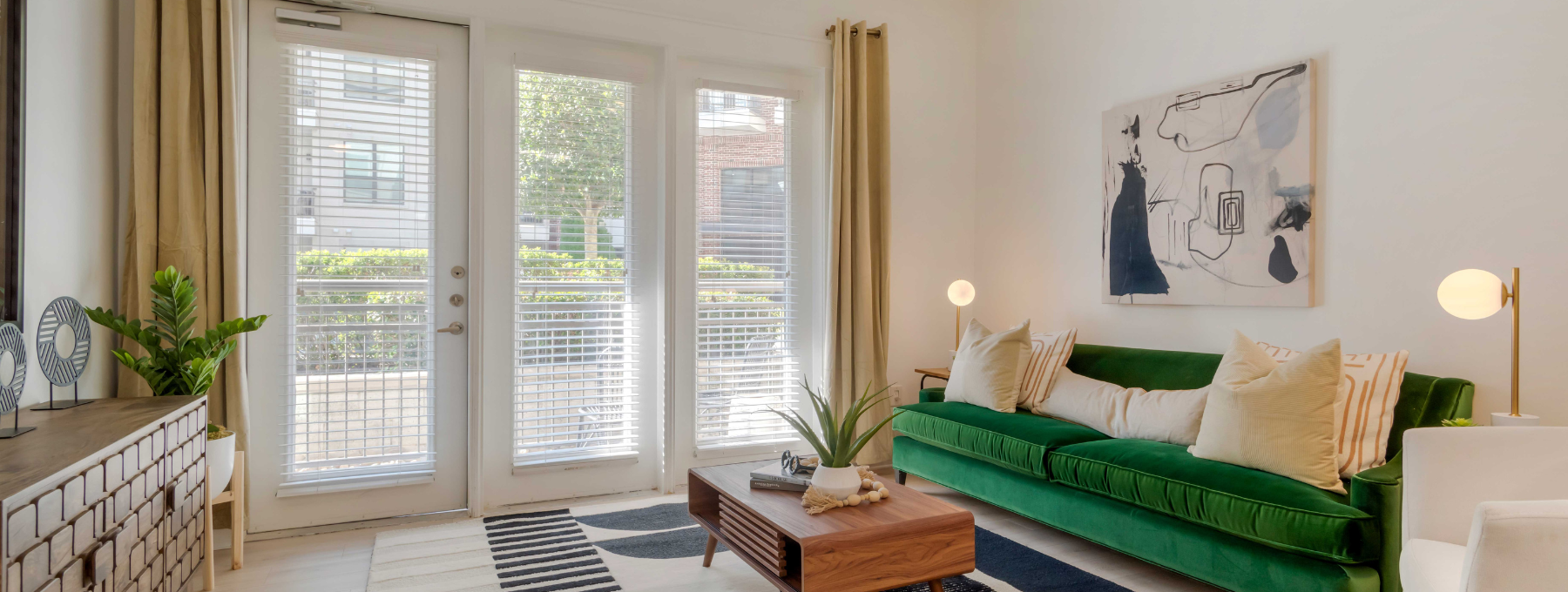 a living room with a green couch and a large window at The Allure