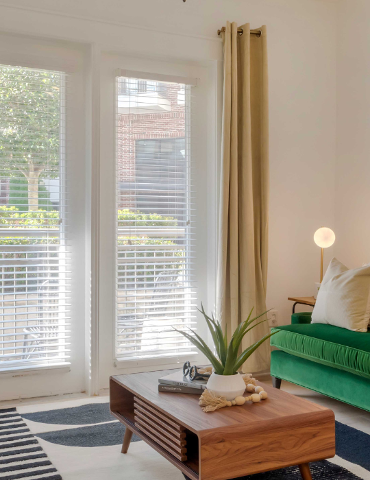 a living room with a green couch and a large window at The Allure